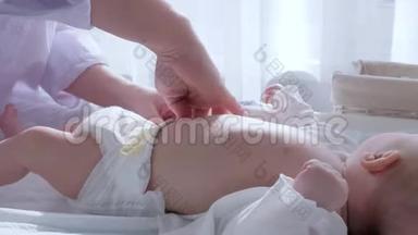婴儿护理，女人正在把尿布换成躺在襁褓中的婴儿